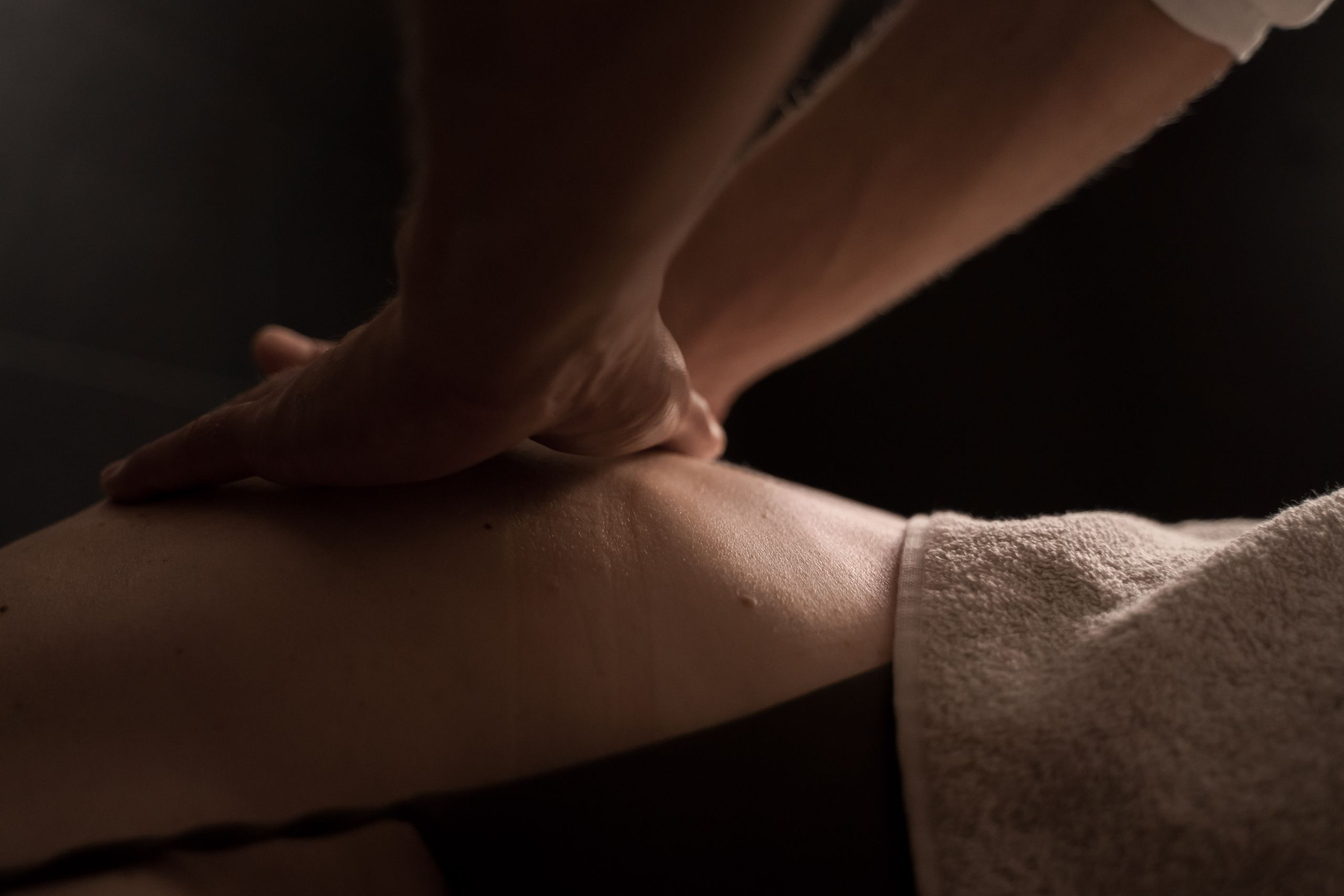 Woman receiving a back massage in warm lighting